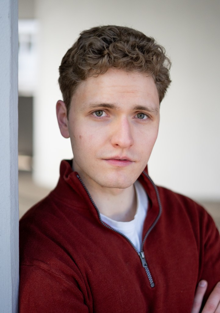 Lukas Baeskow Schauspieler Sänger Schauspielportrait ernster Blick roter Pullover