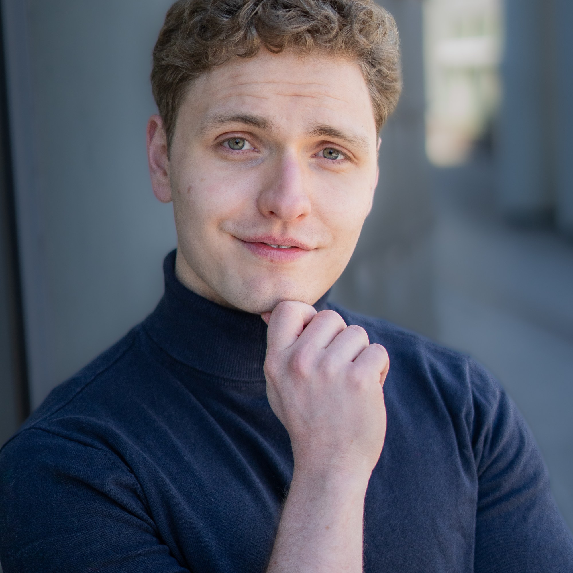 Lukas Baeskow Schauspieler Sänger lächelnd nachdenklich blauer Rollkragen